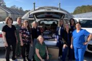 PCM nursing staff standing in front of SUV packed with food donations