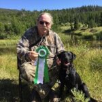 Charlie Man posing with ribbon award and dog