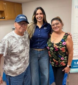 a man and two women standing with their arms around each other
